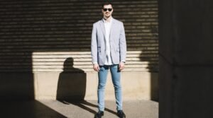 "Man wearing a denim jacket paired with tailored suit trousers, showcasing a modern business casual outfit."