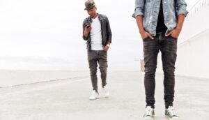 "Young man wearing a denim jacket and joggers, showcasing modern street style."