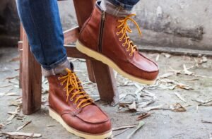 "Man wearing denim jeans paired with leather boots, showcasing a casual yet polished outfit."