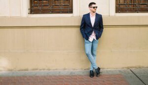 "Man wearing a denim jacket and chinos, showcasing a modern business-casual outfit outdoors."