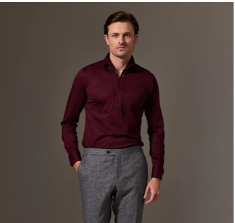 Man wearing grey pants and a burgundy shirt in a stylish and bold outfit