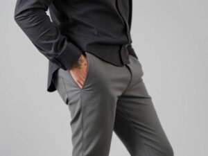 Man dressed in grey pants and a charcoal shirt creating a sleek monochrome outfit