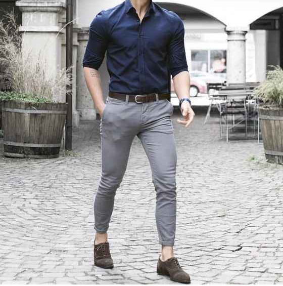 Man wearing grey pants with a navy blue shirt in a smart, stylish outfit