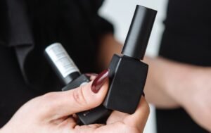 Base and top coat bottles with matte black nail polish setup