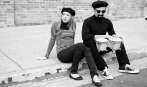 Person dressed in classic Beatnik fashion with a black turtleneck, beret, and minimalist styling.